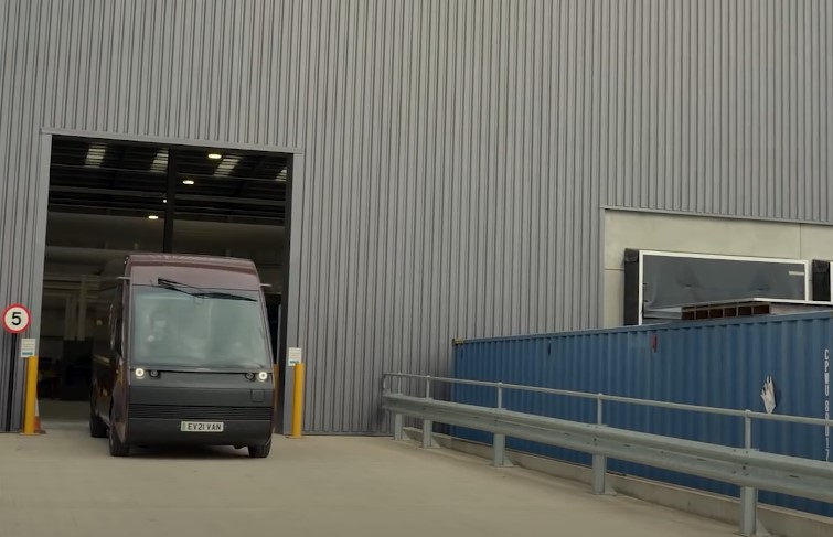 A van is parked in front of a large warehouse
